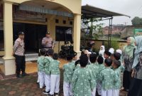 Anggota Polsek Selomerto, AIPDA Agung Ari Fianto dan BRIPKA Untung sedang menyambut para siswa RA Masyitoh Al Munawaroh, Kamis (12/12/24).