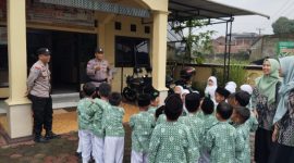 Anggota Polsek Selomerto, AIPDA Agung Ari Fianto dan BRIPKA Untung sedang menyambut para siswa RA Masyitoh Al Munawaroh, Kamis (12/12/24).