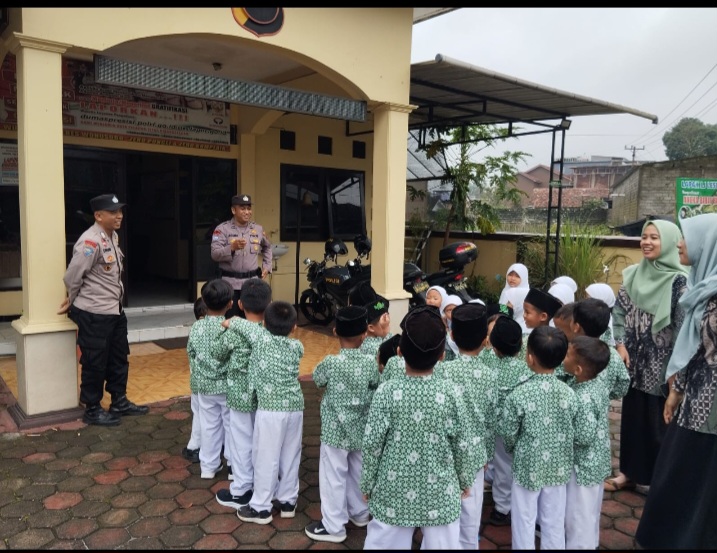 Anggota Polsek Selomerto, AIPDA Agung Ari Fianto dan BRIPKA Untung sedang menyambut para siswa RA Masyitoh Al Munawaroh, Kamis (12/12/24).