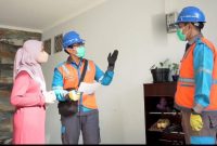 Ilustrasi petugas PLN sedang melayani pelanggan rumah tangga.
