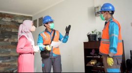 Ilustrasi petugas PLN sedang melayani pelanggan rumah tangga.