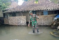 Babinsa Desa Sumberejo Koramil 02/Bonang Kodim 0716/Demak, Serma Rahmat Supriyanto melaksanakan monitoring bencana rob yang merendam rumah warga, Minggu (9/2/2025).