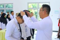 Penjabat (Pj) Bupati Kudus, Herda Helmijaya menglungkan tanda peserta kepada salah satu peserta
Pelatihan Teknis Penyusunan Renstra.

