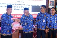 Penjabat (Pj) Bupati Kudus, Herda Helmijaya (kiri) menyerahkan SK Pensiun bagi PNS Pemkab yang memasuki Batas Usia Pensiun per 1 Maret 2025.