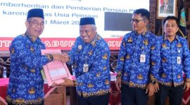 Penjabat (Pj) Bupati Kudus, Herda Helmijaya (kiri) menyerahkan SK Pensiun bagi PNS Pemkab yang memasuki Batas Usia Pensiun per 1 Maret 2025.