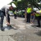 Personel Polres Demak melakukan pengecatan lubang jalan di Jalan Pantura KM 31 + 200 Semarang-Kudus, Desa Bolo, Kecamatan Demak, Kabupaten Demak, Selasa (18/2).