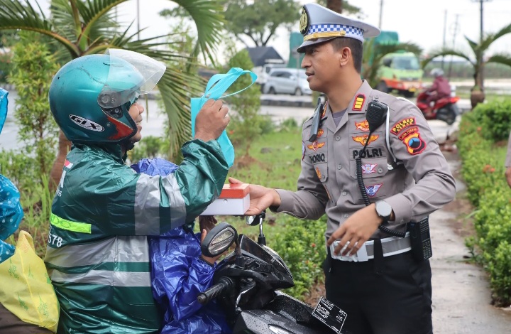 Kasat Lantas Polres Demak, AKP Thoriq Azis membagikan takjil kepada salah seorang pengguna jalan.