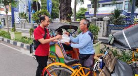 Petugas tim bakti sosial kolaborasi dari Ikatan Apoteker Indonesia Cabang Rembang, Dinas Kesehatan Kabupaten dan dari Gereja Mahanaim sedang menyerahkan takjil kepada seorang pengemudi becak di jalan Kartini Rembang, Jum'at (7/3/2025).