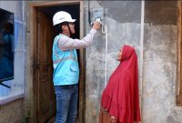 Ilustrasi Petugas PLN sedang melakukan penyambungan listrik gratis di rumah warga kurang mampu.