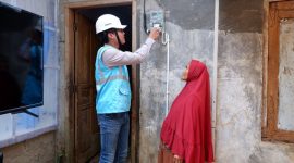 Ilustrasi Petugas PLN sedang melakukan penyambungan listrik gratis di rumah warga kurang mampu.