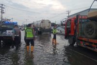 Para personil Polsek Sayung sedang membagikan takjil kepada pengguna jalan Pantura Semarang – Demak, Sabtu (8/3/2025).