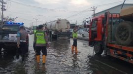 Para personil Polsek Sayung sedang membagikan takjil kepada pengguna jalan Pantura Semarang – Demak, Sabtu (8/3/2025).