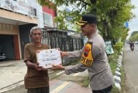 Kapolres Demak, AKBP Ari Cahya Nugraha menyerahkan paket sembako kepada masyarakat yang membutuhkan di Jalan Pemuda Demak, Minggu (9/3/2025).
