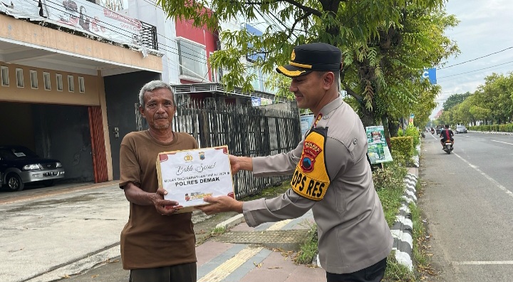 Kapolres Demak, AKBP Ari Cahya Nugraha menyerahkan paket sembako kepada masyarakat yang membutuhkan di Jalan Pemuda Demak, Minggu (9/3/2025).