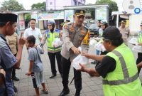 Kapolres Demak, AKBP Ari Cahya Nugraha, membagikan takjil kepada masyarakat di depan Tourist Information Center (TIC) Demak, Minggu (23/3/2025).