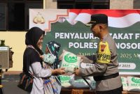 Kapolres Wonosobo, AKBP M. Kasim Akbar Bantilan, membagikan zakat fitrah kepada masyarakat kurang mampu di halaman Polres Wonosobo, Jumat (28/3/2025).
