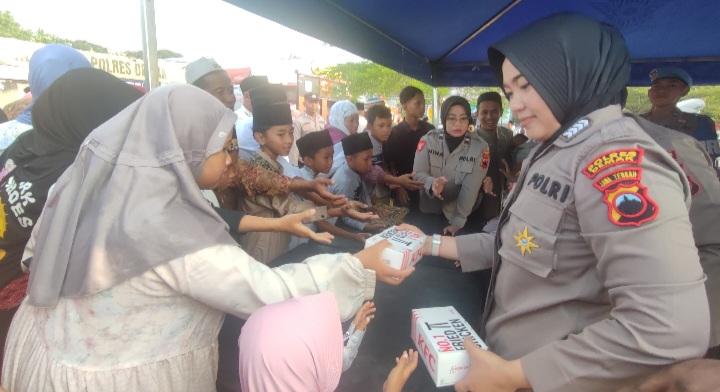 Personel Polres Demak membagikan paket nasi kotak dan minuman kepada jamaah Masjid Agung Demak usai pelaksanaan salat Idul Fitri, Senin (1/4/2025).