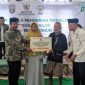 Bupati Rembang, H. Harno (kiri)  menyerahkan bantuan rumah layak huni dan modal usaha kepada para  mustahik di Masjid Agung Rembang, Selasa (27/5/2025).