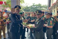 Dandim 0716 Demak, Letkol Kav Maryoto, menyerahkan potongan  tumpeng kepada Kapolres Demak, AKBP Ari Cahya Nugraha setelah upacara HUT Bhayangkara di halaman Polres Demak, Senin (1/7/2025). 