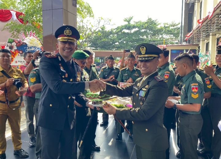 Dandim 0716 Demak, Letkol Kav Maryoto, menyerahkan potongan  tumpeng kepada Kapolres Demak, AKBP Ari Cahya Nugraha setelah upacara HUT Bhayangkara di halaman Polres Demak, Senin (1/7/2025). 