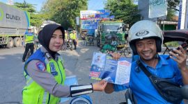 Anggota Satlantas Polres Rembang membagikan brosur tatatertib berlalulintas kepada salah seorang pengendara sepeda motor.