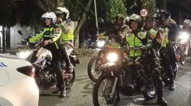 Kapolres Demak, AKBP Ari Cahya Nugraha (pegang HP, membonceng sepeda motor), saat berkeliling menjaga keamanan di wilayahnya.