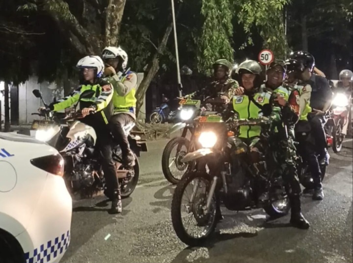 Kapolres Demak, AKBP Ari Cahya Nugraha (pegang HP, membonceng sepeda motor), saat berkeliling menjaga keamanan di wilayahnya.