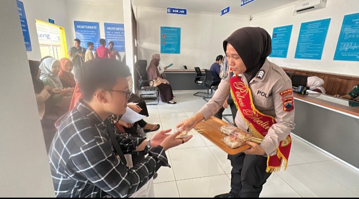 Personil Polwan sedang membagikan snack kepada para pemohon SKCK di Polres Purbalingga.