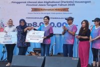 Kepala Eksekutif Pengawas Perilaku Usaha Jasa Keuangan, Edukasi, dan Perlindungan Konsumen OJK,  Frederica Widyasari Dewi, menyerah penghargaan kepada para juara dan duta literasi.