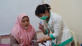 Seorang tenaga kesehatan sedang melayani masyarakat.