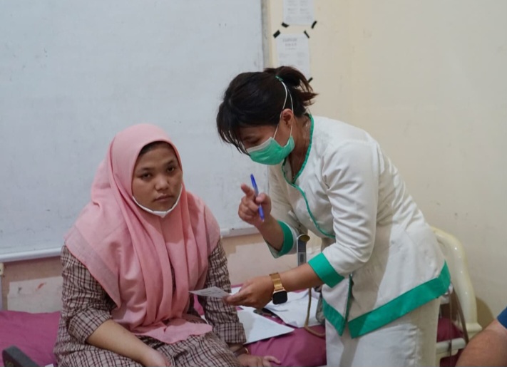 Seorang tenaga kesehatan sedang melayani masyarakat.