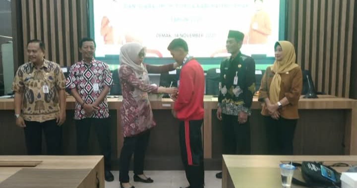 Bupati Demak, Eisti’anah menyerahkan hadiah kepada salah satu atlet pelajar berprestasi di Gedung Gradhika Bina Praja, Jum’at (14/11/25).