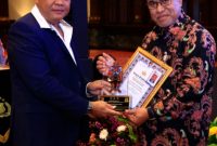 Wakil Kepala Badan Reserse Kriminal Polri, Inspektur Jenderal Polisi Nunung Syaifuddin, menyerahkan penghargaan kepada Kepala Departemen Penyidikan Sektor Jasa Keuangan OJK, Feriansyah dalam acara Rapat Koordinasi Korwas PPNS Tahun Anggaran 2025 yang diselenggarakan di Jakarta (23/10).