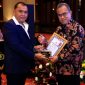 Wakil Kepala Badan Reserse Kriminal Polri, Inspektur Jenderal Polisi Nunung Syaifuddin, menyerahkan penghargaan kepada Kepala Departemen Penyidikan Sektor Jasa Keuangan OJK, Feriansyah dalam acara Rapat Koordinasi Korwas PPNS Tahun Anggaran 2025 yang diselenggarakan di Jakarta (23/10).
