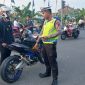 Petugas Satlantas Polres Demak sedang menghentikan pengendara sepeda motor yang menggunakan knalpot tidak sesuai spesifikasi teknis, dalam Operasi Zebra Candi 2025.