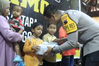 Kapolres Purbalingga, AKBP Achmad Akbar, menyerahan santunan kepada  anak yatim piatu dalam rangka memperingati Hari Ulang Tahun (HUT) Ke-80, Korps Brimob Polri di Gedung Andrawina Owabong, Selasa (18/11/2025). 