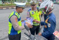 Anggota Satuan Lalu Lintas Polres Demak mensosialisasikan Operasi Zebra Candi 2025 kepada pengendara sepeda motor di Alun-alun Demak, Rabu (19/11/2025). 