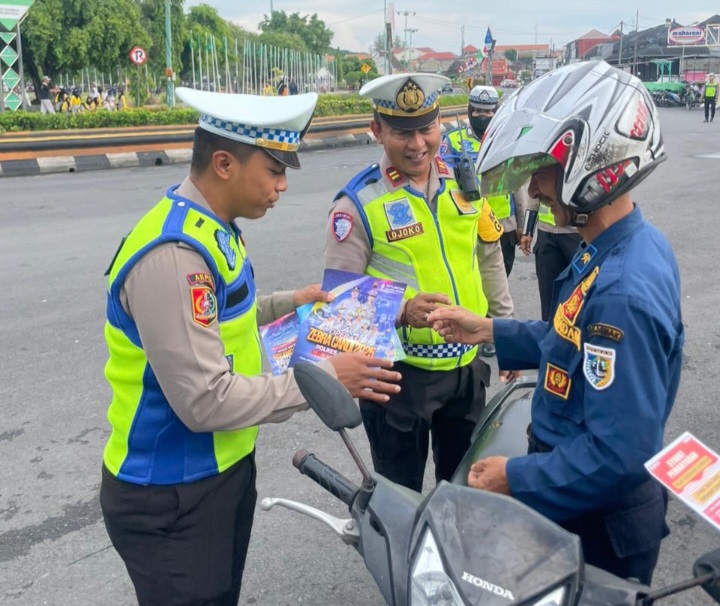 Anggota Satuan Lalu Lintas Polres Demak mensosialisasikan Operasi Zebra Candi 2025 kepada pengendara sepeda motor di Alun-alun Demak, Rabu (19/11/2025). 
