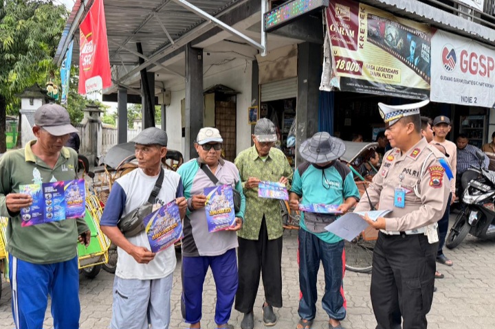 Anggota Stuan Lalu Lintas Polres Demak sedang mensosialisasikan Operasi Zebra Candi 2025 kepada masyarakat.