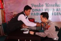 Sidokkes Polres Demak Berikan Pengobatan Gratis di kompleks wisata religi Masjid Agung Demak.
