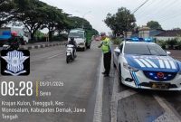 Anggota Satlantas Polres Demak sedang mengatur arus lalulintas di jalur Krajan Kulon, Trengguli.