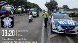 Anggota Satlantas Polres Demak sedang mengatur arus lalulintas di jalur Krajan Kulon, Trengguli.