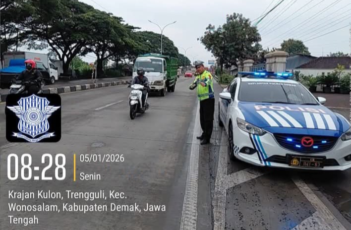 Anggota Satlantas Polres Demak sedang mengatur arus lalulintas di jalur Krajan Kulon, Trengguli.