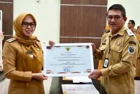 Bupati Demak, Eisti’anah menyerahkan penghargaan kepada Plt. Kadinkominfo, Umar Surya Suksmana di Gedung Gradhika Bina Praja, Senin (26/01/26).