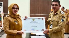 Bupati Demak, Eisti’anah menyerahkan penghargaan kepada Plt. Kadinkominfo, Umar Surya Suksmana di Gedung Gradhika Bina Praja, Senin (26/01/26).