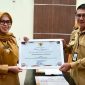 Bupati Demak, Eisti’anah menyerahkan penghargaan kepada Plt. Kadinkominfo, Umar Surya Suksmana di Gedung Gradhika Bina Praja, Senin (26/01/26).