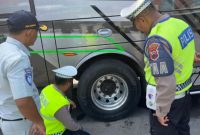 Petugas Satlantas Polres Demak dan Jasa Raharja Kabupaten Demak sedang memeriksa kondisi ban bus di terminal Wisata Kadilangu, Rabu (11/2/2026).