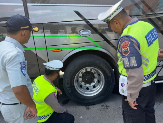 Petugas Satlantas Polres Demak dan Jasa Raharja Kabupaten Demak sedang memeriksa kondisi ban bus di terminal Wisata Kadilangu, Rabu (11/2/2026).