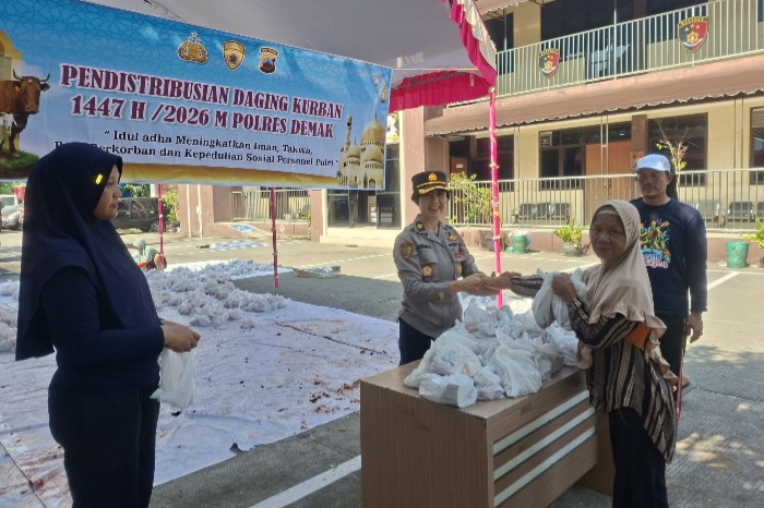 Anggota Polres Demak membagikan daging korban kepada masyarakat di halaman Gedung Wicaksana Laghawa, Satreskrim Polres Demak, Rabu (27/5).