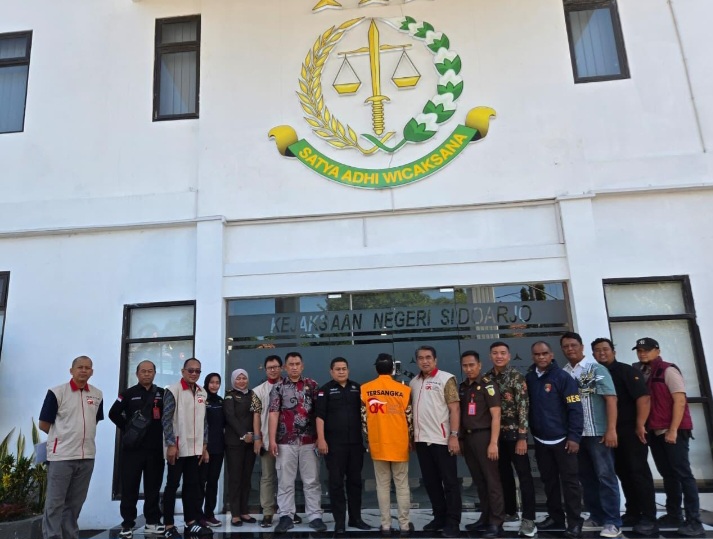 OJK serahkan tersangka berinisial KI (tengah) selaku Direktur Utama PT BPR SAWA kepada Jaksa Penuntut Umum Kejaksaan Negeri Sidoarjo, Kamis (9/7).